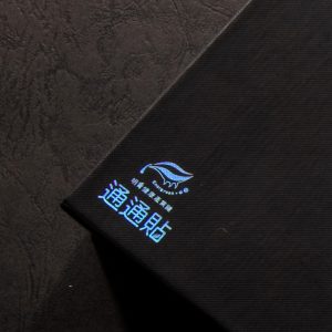 客製化黑色霧P上下蓋盒，特寫表面精密壓紋與炫彩雷射燙金的光影折射